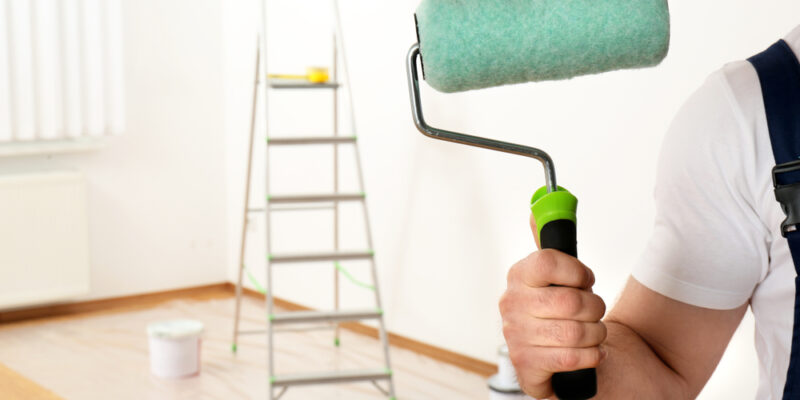 Male,Decorator,With,Paint,Roller,In,Empty,Room,,Closeup.,Space